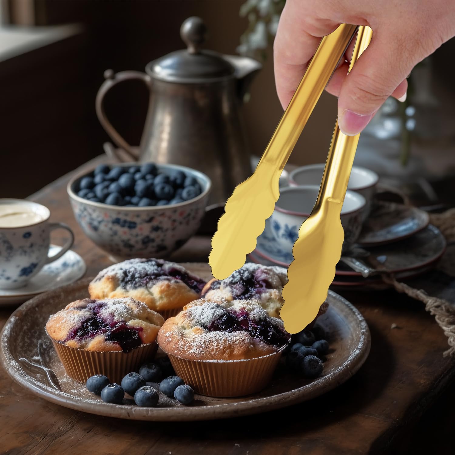 XEVOM stainless steel gold-tone serving tongs in elegant dining setup.