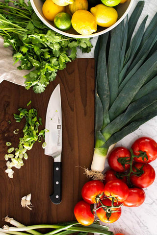 Zwilling Pro in-action knife performing versatile chopping, slicing, and dicing tasks.