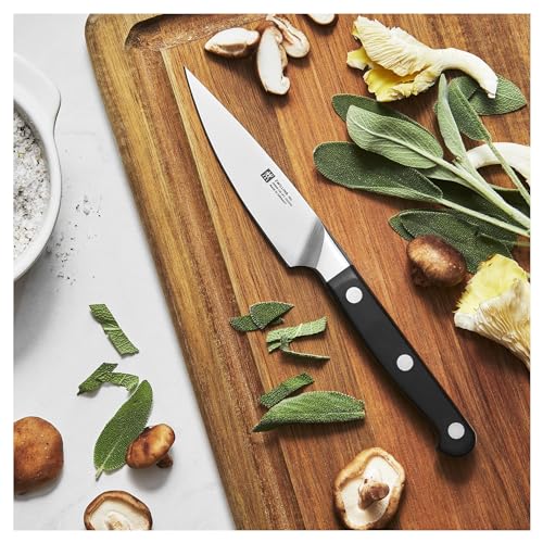 Zwilling Pro paring knife in use for intricate fruit trimming.